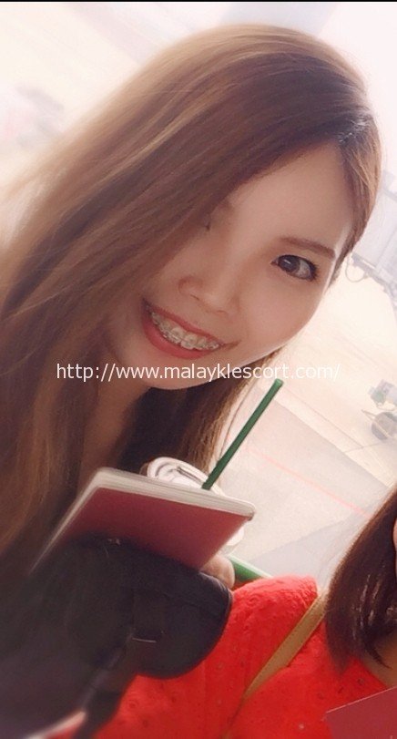 Smiling Japan Girl Hilda with braces, holding a drink. Malay Escort Kuala Lumpur